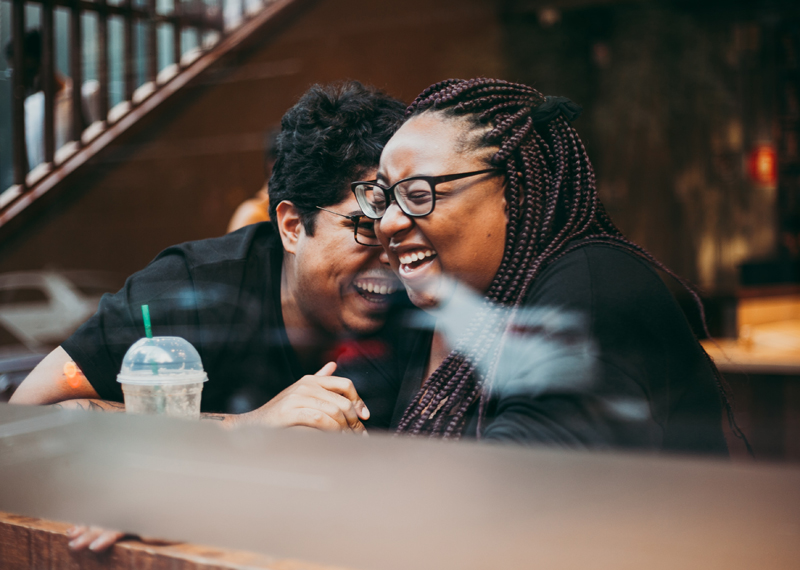 Couple laughing together at a coffee shop